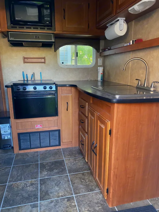 RV rental kitchen: compact, functional space with stove, microwave, sink, and ample storage for your travel adventures.. Forest River Salem 2011