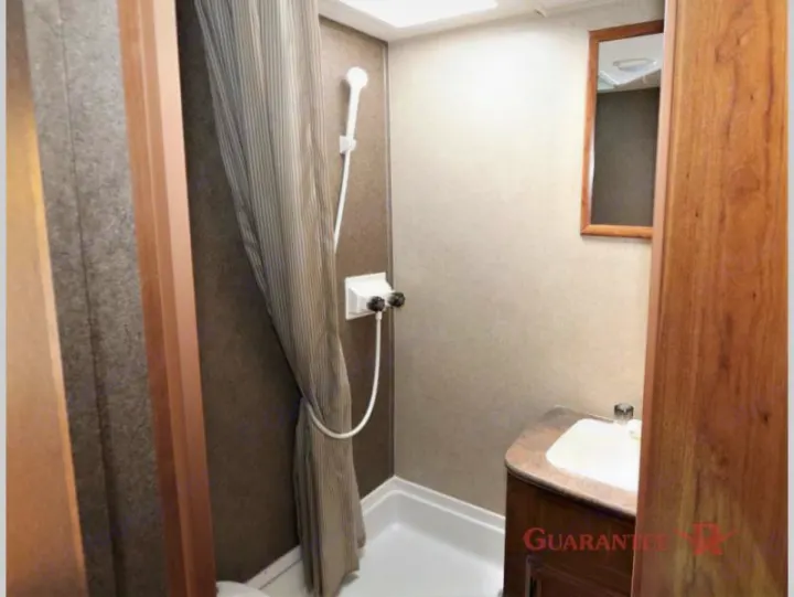Compact RV rental bathroom with a stand-up shower, control knobs, small sink, and mirror.. Starcraft Launch 2016