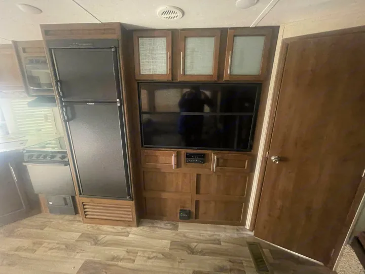 Explore this RV rental's cozy interior, featuring a full kitchen with fridge, and a built-in entertainment system.. Keystone Cougar Half-Ton 2018