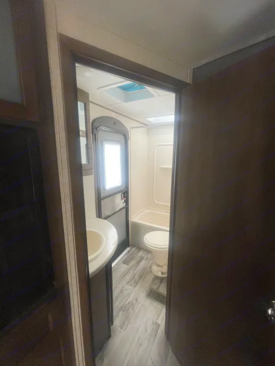 Experience a typical RV rental bathroom: complete with compact sink, toilet, and shower/tub. Practical for on-the-go living.. Keystone Cougar Half-Ton 2018