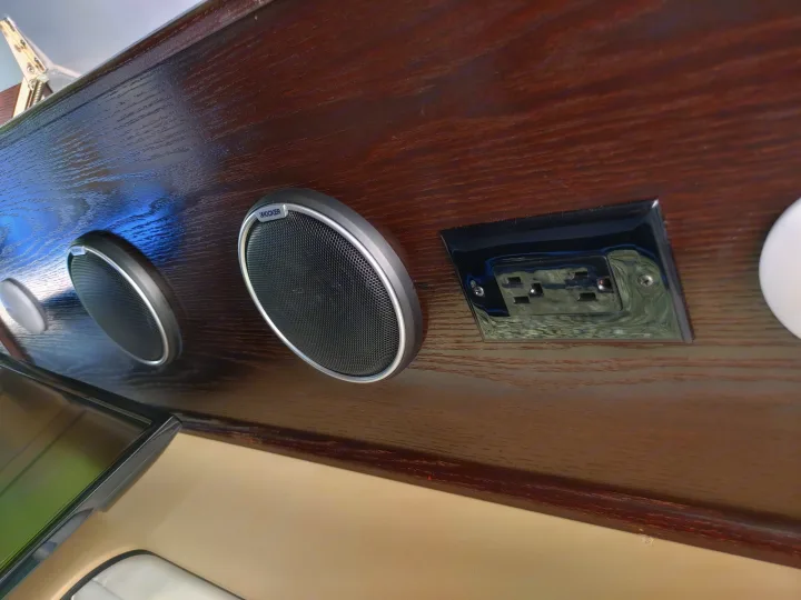 Kicker speakers and electrical outlet mounted on wood paneling inside an RV rental.. Regency RV National Traveler 2019