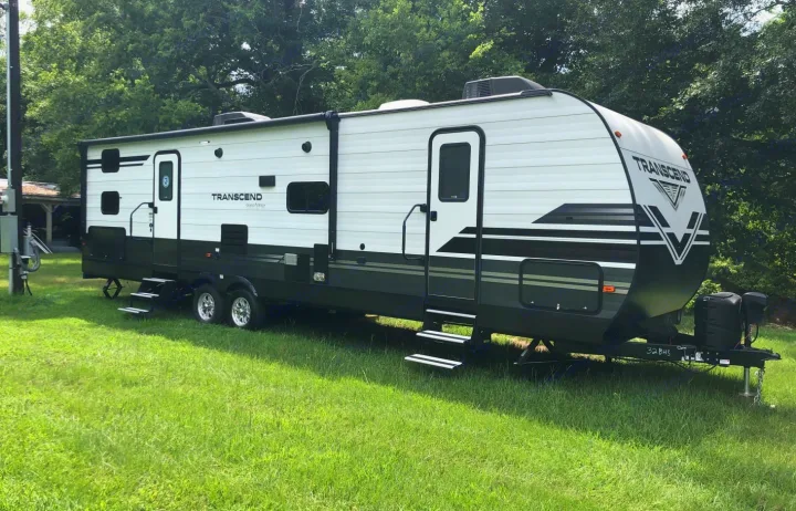 This white and black Grand Design Transcend travel trailer could be your next rv rental, parked on lush grass.. Grand Design Transcend 2020