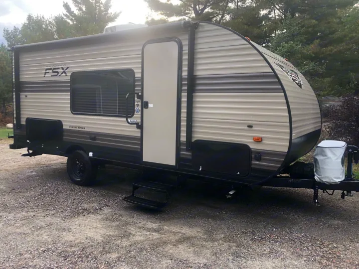 Tan Forest River Wildwood FSX travel trailer on gravel, perfect for an rv rental road trip.. Forest River Wildwood FSX 2020