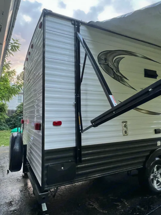 Exterior view of a travel trailer with an extended awning & rear spare tire, perfect for an rv rental.. Coachmen Clipper 2016