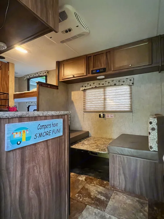 Cozy RV rental interior with dinette, bunk beds, and overhead cabinets, ready for adventures.. Coachmen Clipper 2016