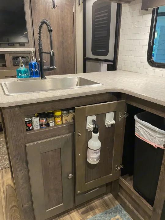 RV rental kitchen: Sink with soap, built-in spice rack, and a convenient pull-out trash can demonstrate smart storage.. Cruiser RV MPG Ultra Lite 2019