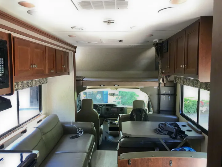 Full view of a modern RV rental interior featuring a spacious living area, dinette, kitchen, and overhead bunk.. Forest River Sunseeker 2017