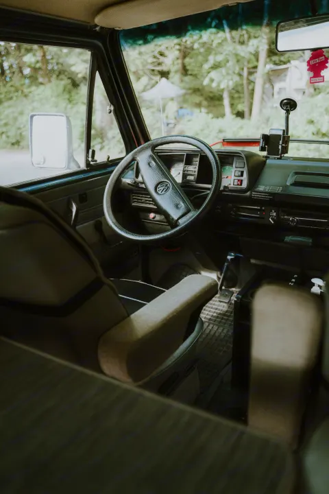 Vintage VW camper van interior for your next rv rental adventure, showing dashboard, steering wheel, and front seats.. Volkswagen Vanagon 1991