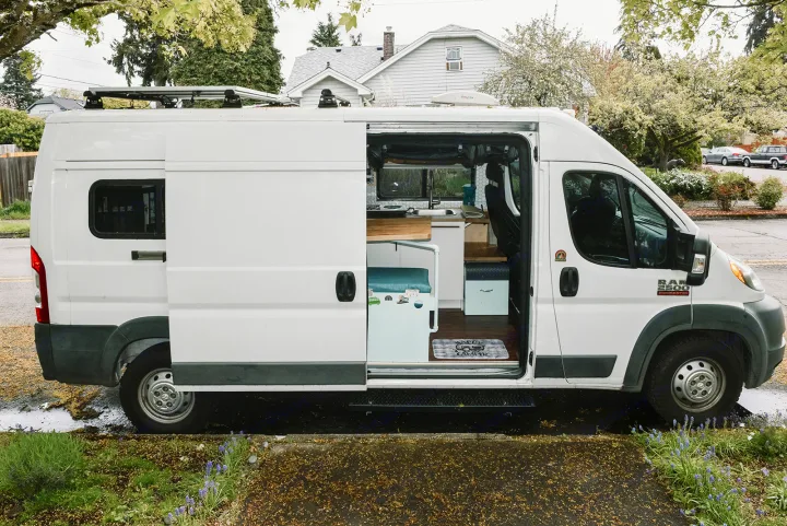 This white RV rental camper van shows its open side door, revealing a functional interior with kitchen & living space.. Other Other 2016