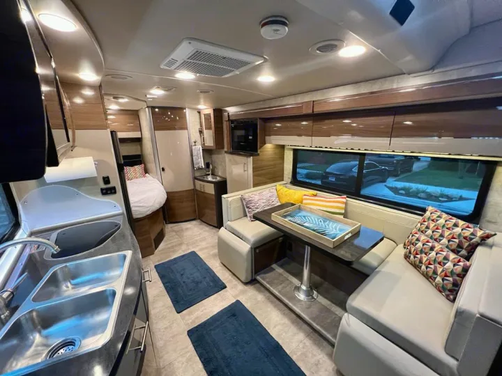 Step inside this modern RV rental! Features a full kitchen, comfy dinette, and spacious living area, perfect for travel.. Itasca Navion 2015