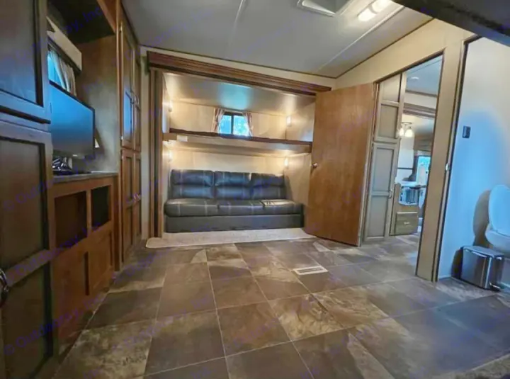 RV rental interior features bunk beds, a sofa, and a TV unit, offering a cozy living space for your road trip comfort.. Crossroads RV Rezerve 2016