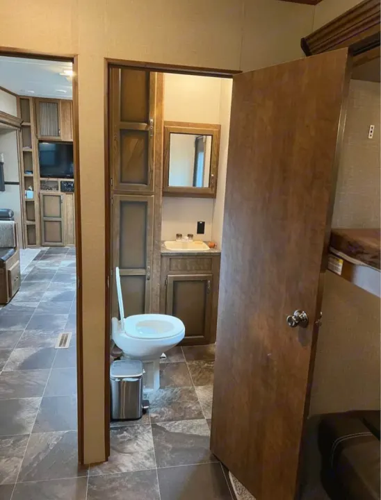 Compact RV rental interior showcases a functional bathroom with toilet & sink, plus an adjacent living area. Practical design.. Crossroads RV Rezerve 2016
