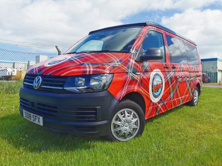 Experience an rv rental with The Tartan Camper Co.'s distinctive red tartan Volkswagen campervan parked on grass.. Volkswagen T6 Transporter LWB 2018