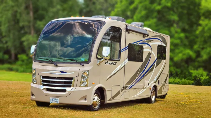 This beige Thor Vegas RV rental, a Class C motorhome, is parked on a grassy field, ready for travel adventures.. Thor Vegas 2014