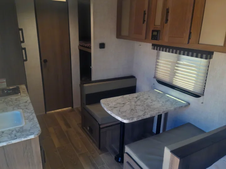 This RV rental interior features a cozy kitchen, dinette, and bunk beds, perfect for family adventures.. Gulf Stream Ameri-Lite Super Lite 2021
