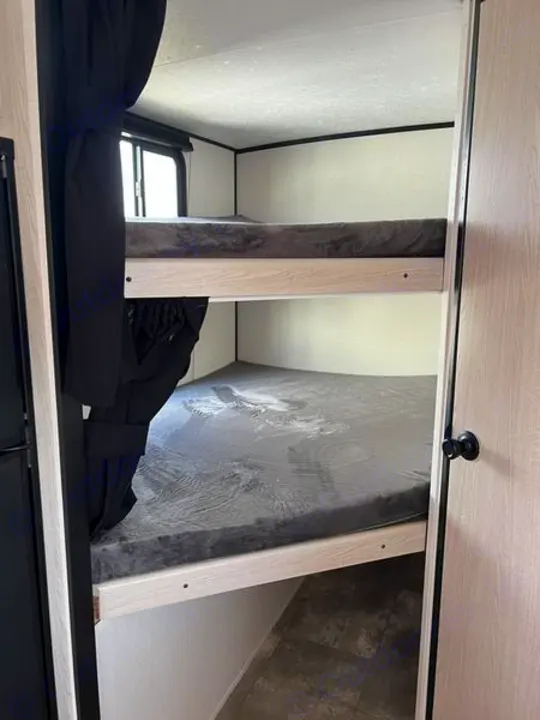 RV rental: Interior shot of two bunk beds with gray mattresses & light wood frames. A window is visible.. Other Other 2022
