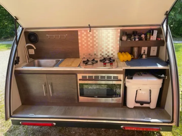 RV rental: Compact outdoor kitchen with a sink, stove, microwave, & cooler for versatile camping meal prep.. NuCamp T@G MAX XL BOONDOCK 2021