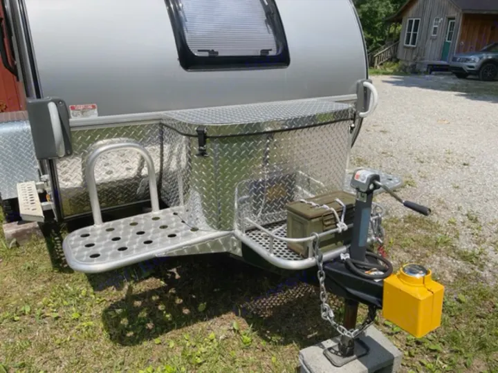 Explore outdoors with this RV rental trailer, featuring diamond plate storage, front step, and hitch setup.. NuCamp T@G MAX XL BOONDOCK 2021