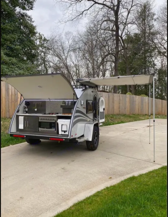 An rv rental compact teardrop trailer with an outdoor kitchen setup and side awning extended, ready for travel.. NuCamp T@G MAX XL BOONDOCK 2021
