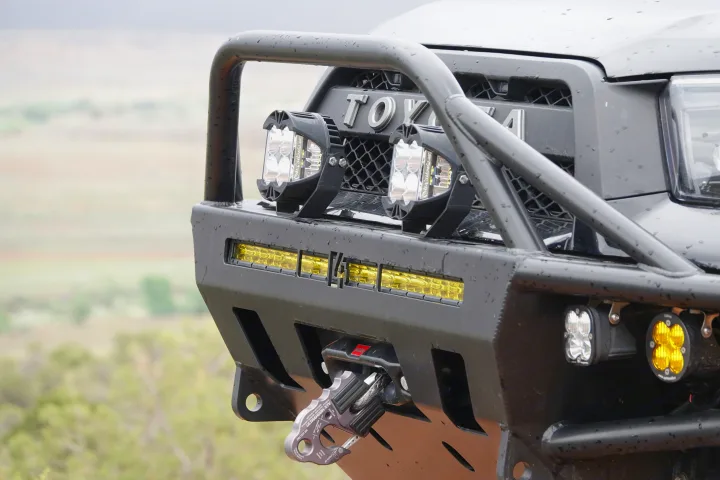 Close-up of a rugged Toyota's front bumper with LED lights, bull bar, and a Factor 55 recovery hook, ready for off-road RV rental fun.. Toyota 4Runner 2013