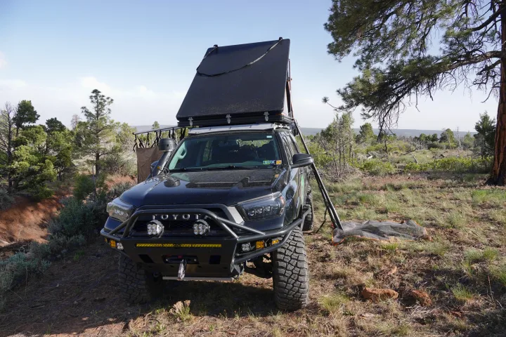 An overlanding Toyota 4Runner with roof-top tent deployed. Like an rv rental, it's set for off-road camping.. Toyota 4Runner 2013