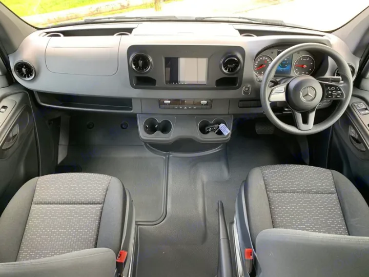 RV rental cabin: Mercedes-Benz van interior with dashboard, steering wheel, and front seats.. Mercedes-Benz Sprinter 2022