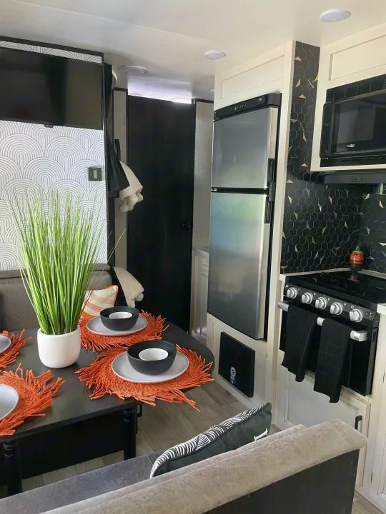 Modern RV rental interior showcasing a compact kitchen with stylish hexagonal backsplash and a cozy dining area.. Jayco JAYCO JAY FLIGHT SLX 264BH 2022