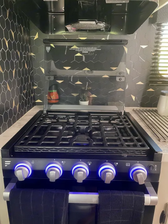 Discover the sleek black gas range with illuminated knobs in this modern RV rental kitchen. Features a stylish hexagonal tile backsplash.. Jayco JAYCO JAY FLIGHT SLX 264BH 2022