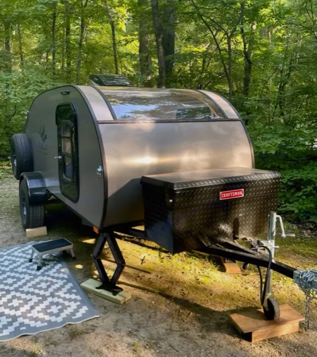 Cozy teardrop camper set up in a wooded campsite, ideal for an RV rental adventure. Ready for glamping!. Driftwood Trailers Other 2022