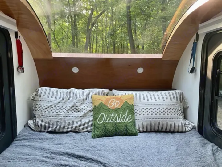Cozy RV rental interior: bed with pillows, panoramic forest view. Perfect for camping and glamping adventures!. Driftwood Trailers Other 2022