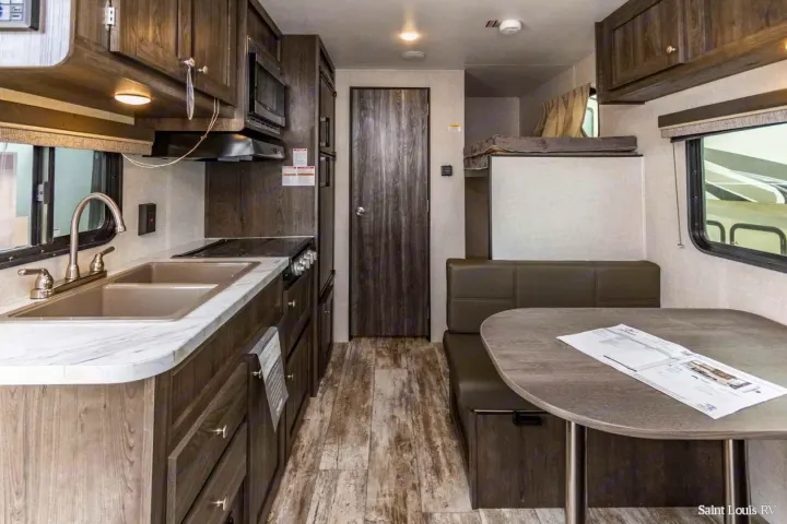 Explore this RV rental's functional interior: compact kitchen, dinette, and cozy bunk beds.. Highland Ridge RV Open Range 2020