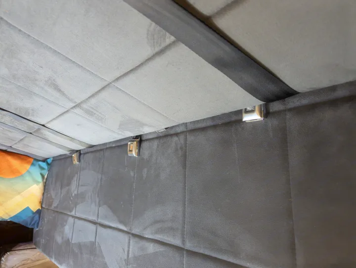Upward view inside an RV rental: quilted grey panels, dark securing strap, and gleaming buckles.. Freightliner Sprinter Van 2012
