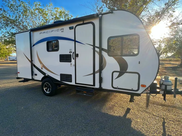 Sunlit Pacifica XL travel trailer, ideal for your next rv rental adventure, parked on asphalt.. Pacific Coachworks Pacifica XL 2020