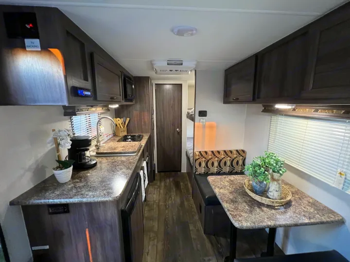 Cozy RV rental interior showing a functional kitchen, dining area, and bunk beds.. Pacific Coachworks Pacifica XL 2020