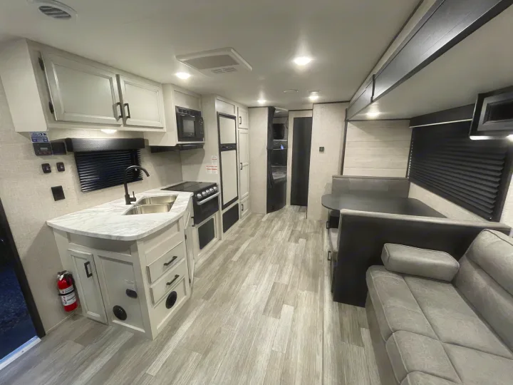 Modern RV rental interior featuring a well-equipped kitchen, a dinette, and a comfy living area.. Jayco Jay Flight 2022