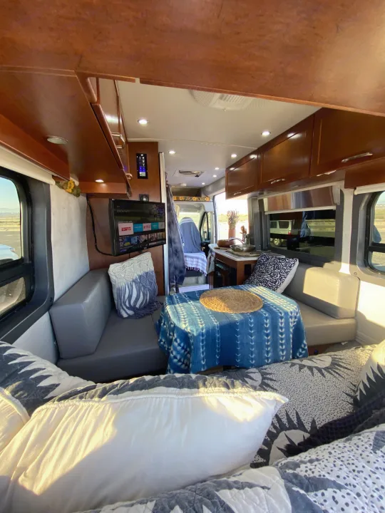 Cozy rv rental interior with a comfy living space, dining table, and compact kitchen. Experience mobile comfort.. Pleasure-Way Pleasure-Way Class B 2016
