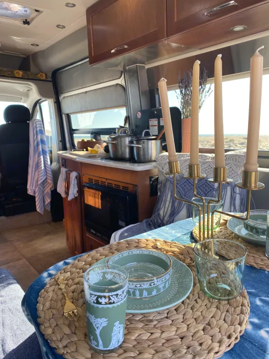 Enjoying a cozy RV rental dining setup with a beach view, featuring a compact kitchen and elegant table settings.. Pleasure-Way Pleasure-Way Class B 2016