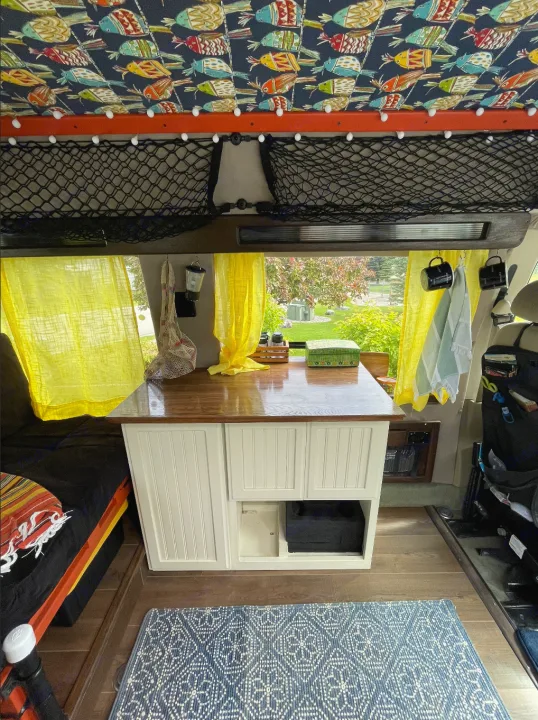 Cozy RV rental interior with custom fish ceiling, kitchen counter, and bright window view.. Ford Econoline 2006