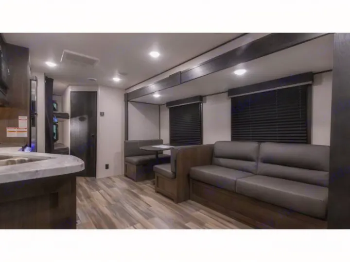RV rental interior featuring a cozy living area with sofa, dinette, kitchen, and bunk beds. Perfect for travel.. Autumn Ridge 26BHS 2022