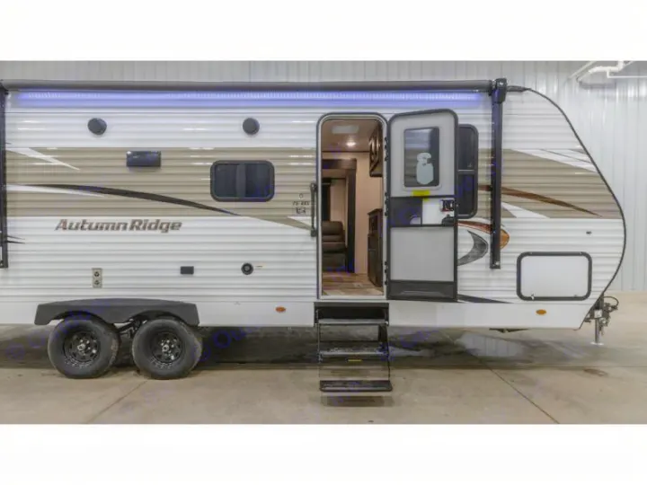 Autumn Ridge travel trailer, perfect for your next RV rental. Open door reveals a peek inside this adventure-ready camper.. Autumn Ridge 26BHS 2022