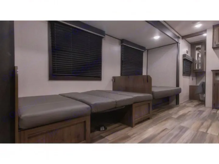 This RV rental features a versatile interior with convertible bench seating, wood-look floors, and window blinds.. Autumn Ridge 26BHS 2022