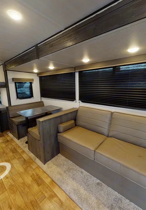 RV rental: Bright interior showing dining booth, sofa, and windows with dark blinds.. Keystone Hideout 2022