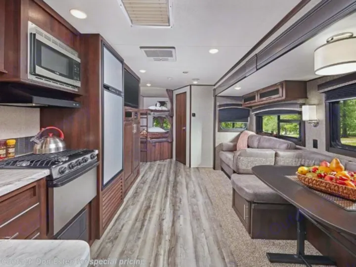 Spacious, modern RV rental interior showing a kitchen, living area with dining table, and rear bunk beds.. Jayco Jay Flight 2020