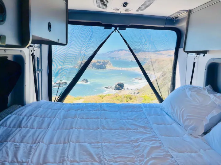 This RV rental offers a comfy bed with a stunning ocean view through the mesh screen. Ideal for travel!. Winnebago solis 2022