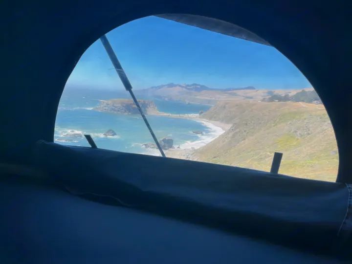Enjoy a panoramic coastal view from this RV rental, showcasing the ocean, cliffs, and rolling hills. Perfect for scenic travel.. Winnebago solis 2022