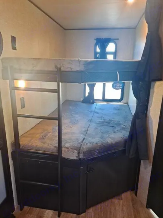 RV rental interior: cozy bunk beds with ladder & storage base, ideal for compact sleeping in a travel trailer.. Jayco JayFlight 28BHS TT 2022