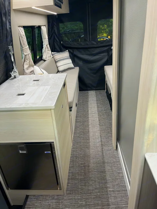 Discover this rv rental interior: compact kitchen, cozy seating, and modern amenities for your next adventure.. Tiffin Motorhomes Cahaba 2021