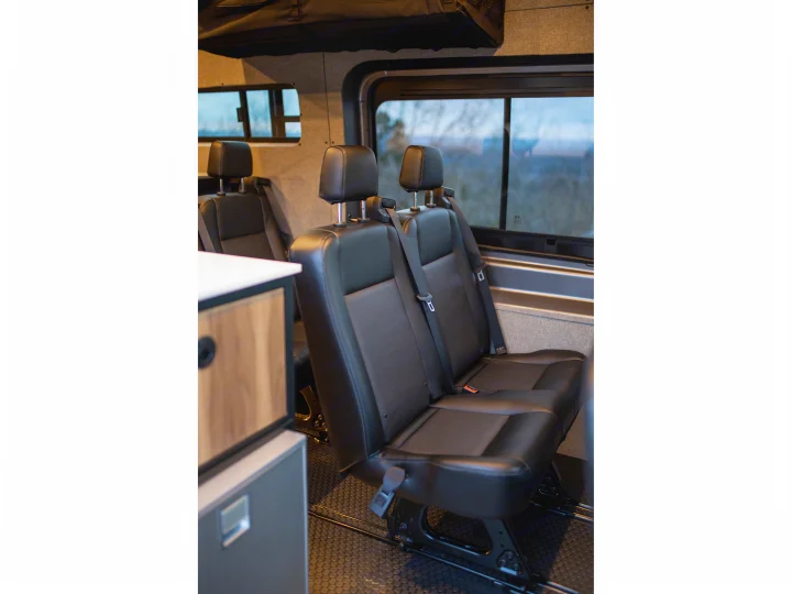 Inside a modern RV rental: comfortable black passenger seats visible, ready for your next adventure.. Ford Transit 2021