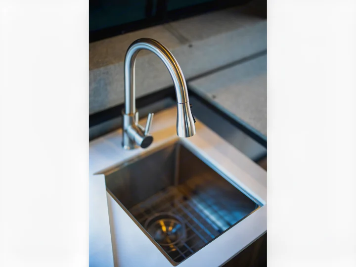 Modern stainless steel sink and faucet in a compact RV rental kitchen.. Ford Transit 2021