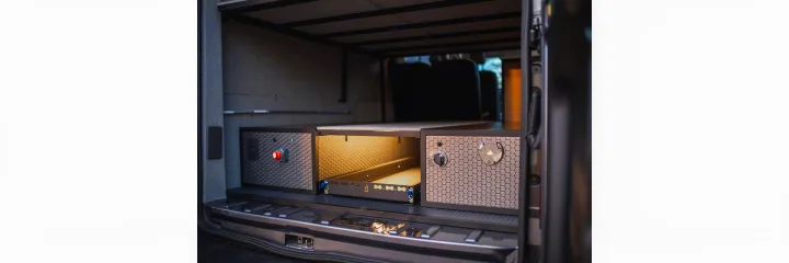 RV rental van's rear: modular storage system, illuminated pull-out drawer, and controls for mobile living.. Ford Transit 2021
